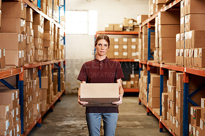 Buy stock photo Portrait of a young woman holding a box while working in a warehouse