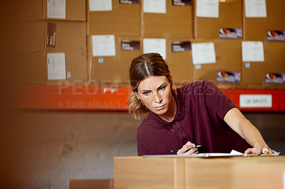 Buy stock photo Shot of a young woman working in a warehouse