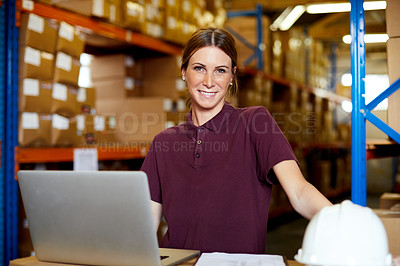 Buy stock photo Portrait of a young woman using a laptop in a warehouse