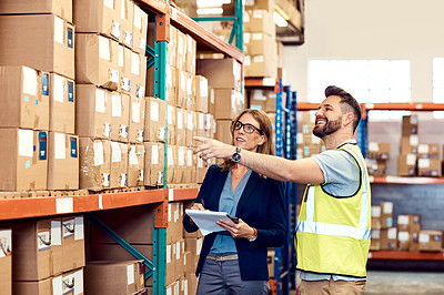 Buy stock photo Shot of a young man and woman working together in a warehouse