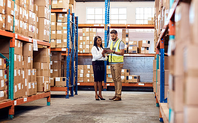 Buy stock photo Shot of a man and a woman using a digital tablet together in a warehouse