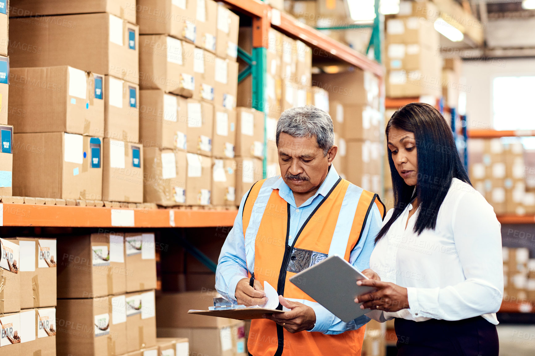 Buy stock photo Shot of a mature man and woman working together in a warehouse