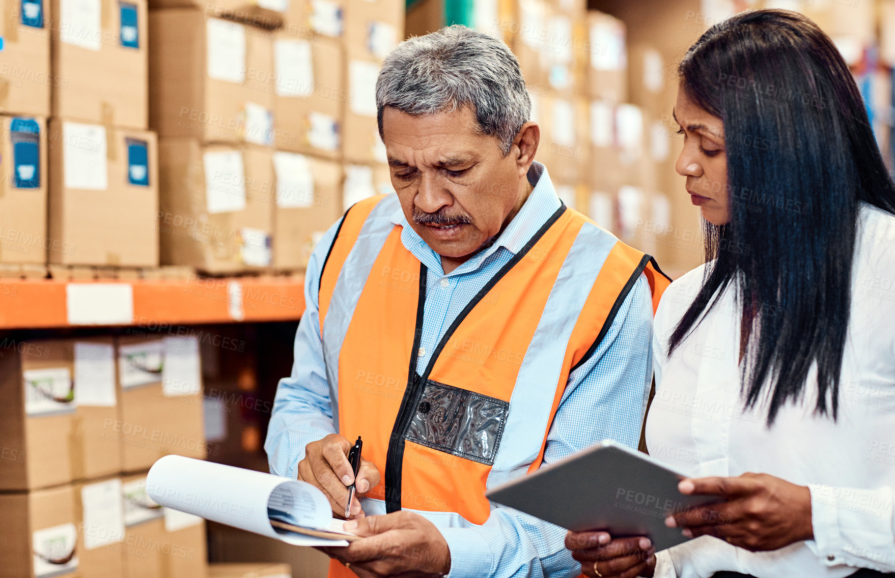 Buy stock photo Shot of a mature man and woman working together in a warehouse