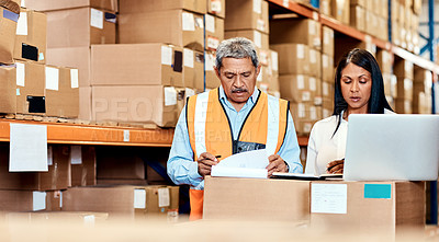 Buy stock photo Shot of a mature man and woman going through paperwork together in a warehouse