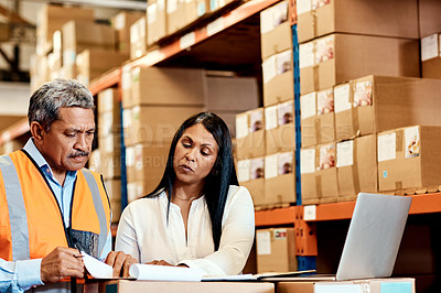 Buy stock photo Shot of a mature man and woman going through paperwork together in a warehouse