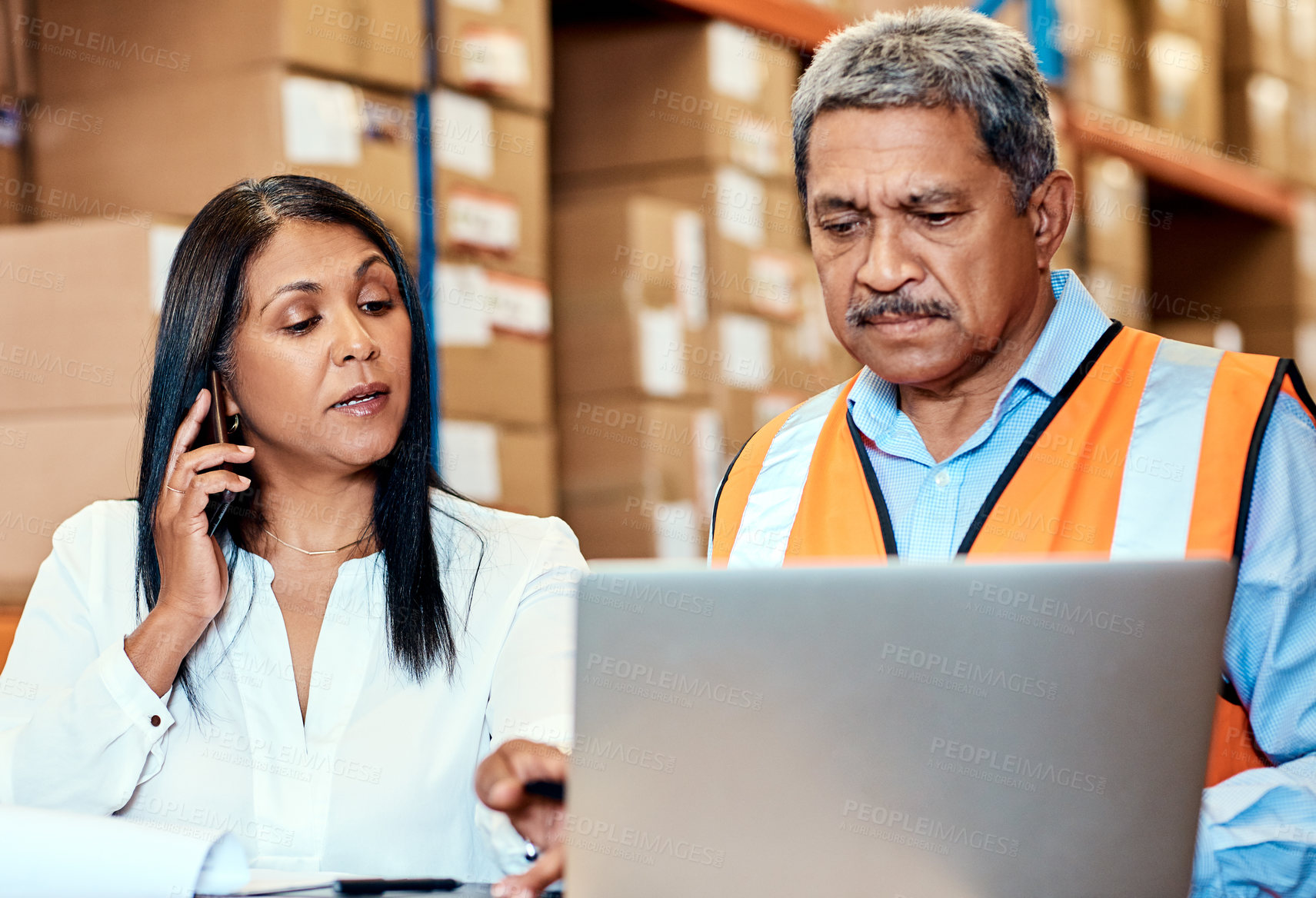 Buy stock photo Shot of a mature man and woman working together in a warehouse