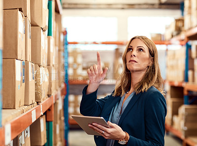 Buy stock photo Shot of a young factory manager using a digital tablet in a warehouse