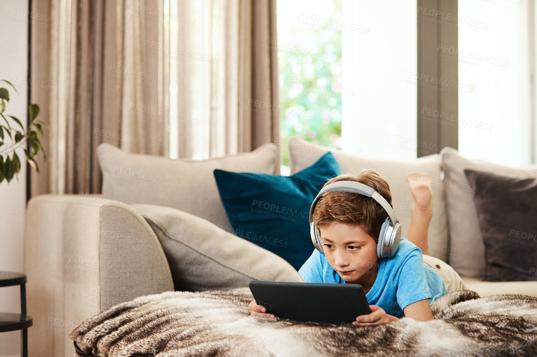 Buy stock photo Headphones, weekend and child on tablet on sofa for watching movies, games and videos to relax. Home, internet and boy on digital tech for streaming cartoons, online entertainment or website on couch