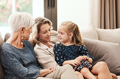 Buy stock photo Shot of a happy senior woman relaxing on the sofa with her daughter and granddaughter at home