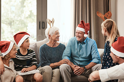 Buy stock photo Cropped shot of a cheerful family seated together while wearing festive hats during Christmas time