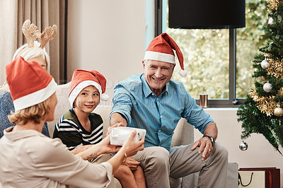 Buy stock photo Cropped shot of a cheerful young woman giving her dad a present during Christmas time