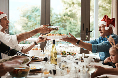 Buy stock photo Cropped shot of a cheerful family having a celebratory toast together at a lunch table during Christmas time