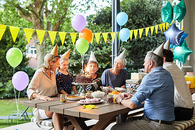 Buy stock photo Shot of a happy family celebrating a birthday at home in the garden