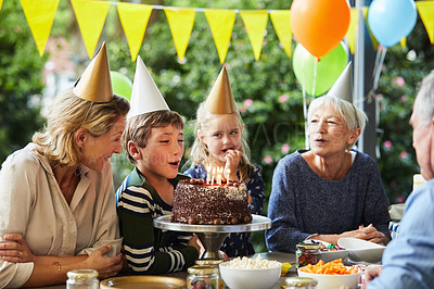 Buy stock photo Shot of a happy family celebrating a birthday at home in the garden