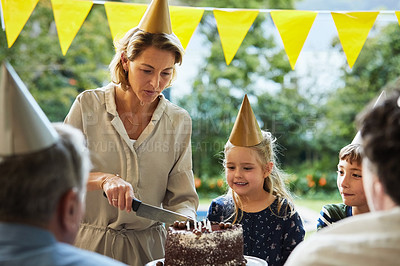 Buy stock photo Shot of a happy family celebrating a birthday at home in the garden