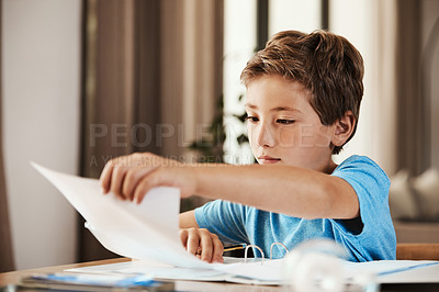 Buy stock photo Shot of a cute little boy doing his homework at home