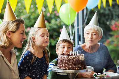 Buy stock photo Shot of a happy family celebrating a birthday at home in the garden