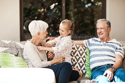 Buy stock photo Shot of an adorable little girl spending quality time with her grandmother and grandfather outside at home