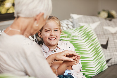Buy stock photo Shot of a senior woman and her granddaughter spending quality time outside at home