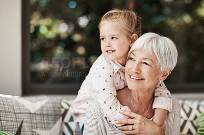 Buy stock photo Shot of a senior woman and her granddaughter playing together outside at home