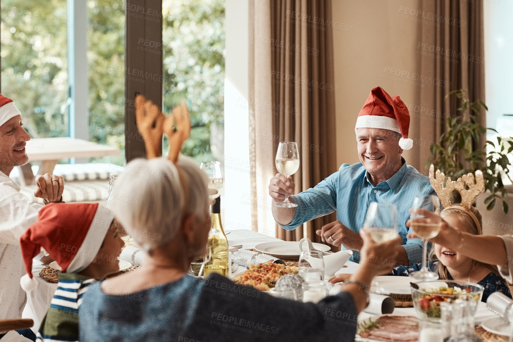 Buy stock photo Big family, happy and Christmas lunch with toast, celebration and festive with drinks in home. Grandparents, parents and children smile for holiday gathering, dinner party and cheers with wine