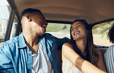 Buy stock photo Shot of a happy young couple going on a road trip with friends