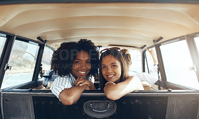 Buy stock photo Shot of two happy young friends going on a road trip together