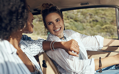 Buy stock photo Shot of a two happy young friends going on a road trip together