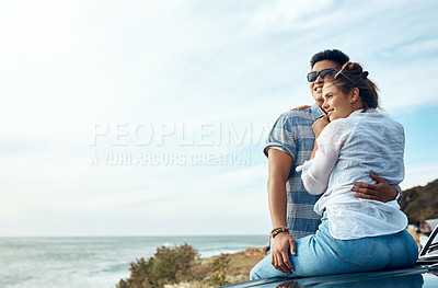 Buy stock photo Shot of a happy young couple looking at the view on a road trip along the coast