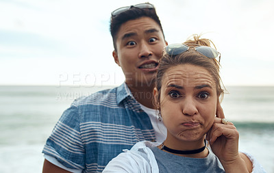 Buy stock photo Portrait of a happy young couple making funny faces on a vacation along the coast