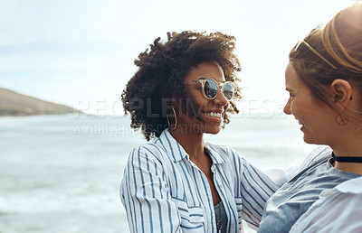 Buy stock photo Shot of two happy young friends enjoying a vacation along the coast