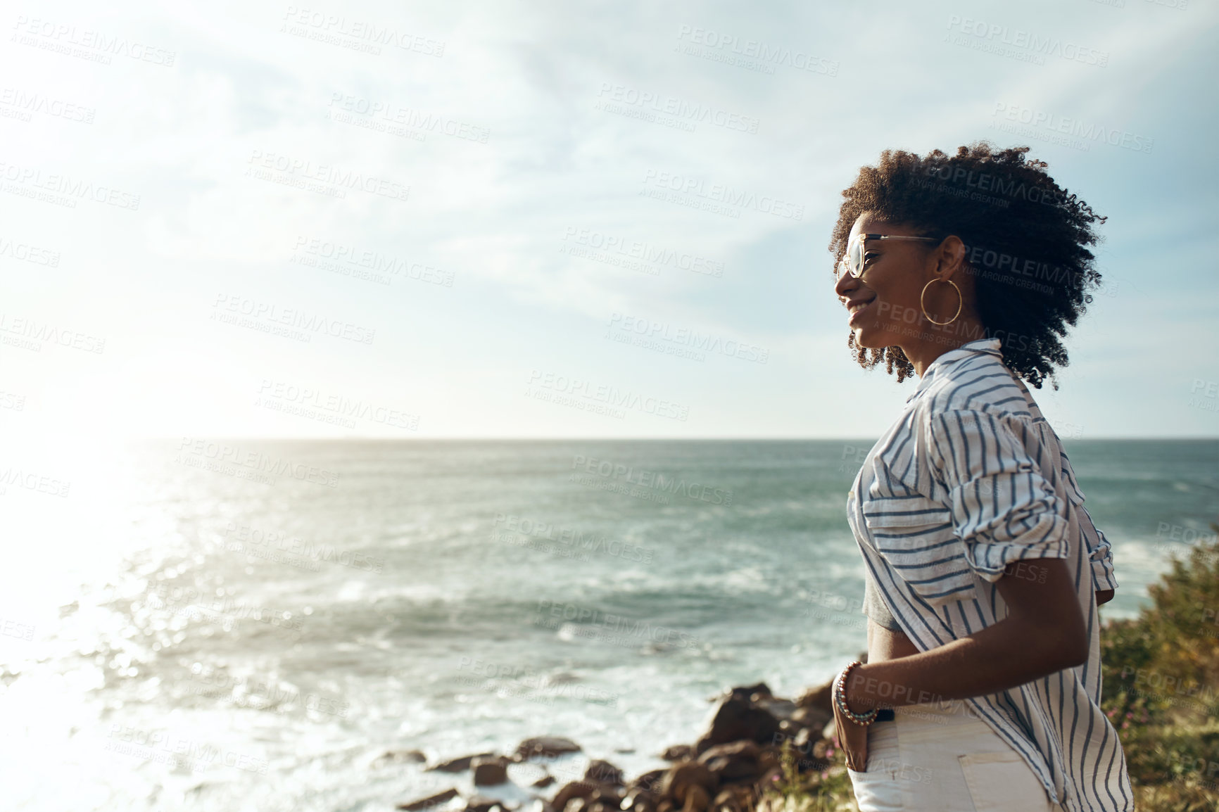 Buy stock photo Shot of an attractive young woman enjoying a vacation along the coast