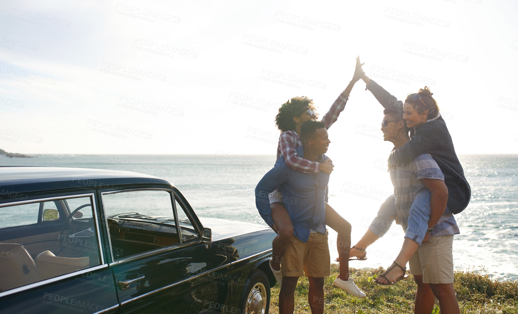 Buy stock photo Shot of a group of happy young friends having fun on a road trip along the coast