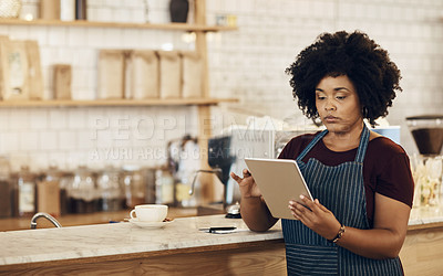 Buy stock photo Shot of a coffee owner using a digital tablet while standing in her cafe