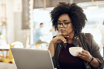 Buy stock photo Cropped shot of a young woman enjoying a cup of coffee while using her laptop in a cafe