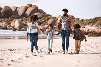 Buy stock photo Shot of an adorable little boy and girl going for a walk along the beach with their parents