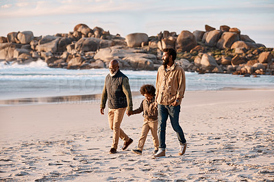 Buy stock photo Shot of an adorable little boy going for a walk along the beach with his grandfather and father