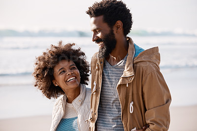 Buy stock photo Shot of a happy young couple going for a romantic walk along the beach