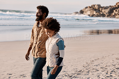 Buy stock photo Shot of a happy young couple going for a romantic walk along the beach