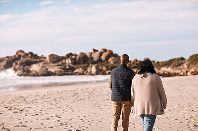 Buy stock photo Shot of a happy mature couple going for a romantic walk along the beach
