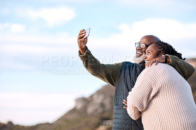 Buy stock photo Shot of a happy mature couple taking selfies with a smartphone at the beach