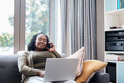 Buy stock photo Shot of a mature woman talking on a cellphone while using a laptop at home