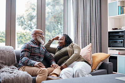 Buy stock photo Shot of a mature couple relaxing together on a sofa at home