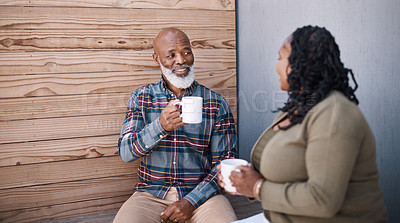 Buy stock photo Shot of a mature couple drinking coffee while having a chat outdoors