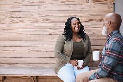 Buy stock photo Shot of a mature couple drinking coffee while having a chat outdoors