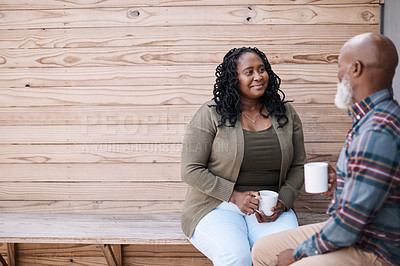 Buy stock photo Shot of a mature couple drinking coffee while having a chat outdoors