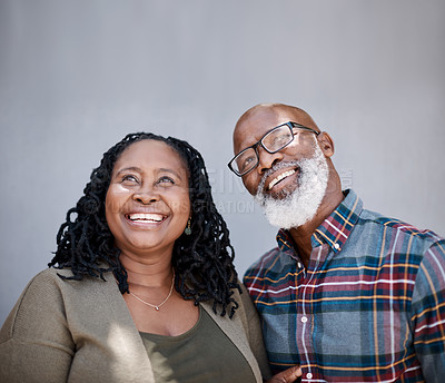 Buy stock photo Shot of a mature couple looking thoughtful against a grey background
