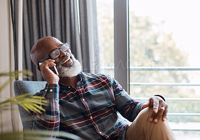 Buy stock photo Shot of a mature man talking on a cellphone while relaxing on a sofa at home