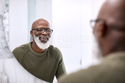 Buy stock photo Shot of a mature man looking at his face in the bathroom at home