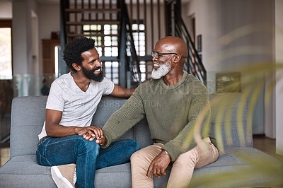 Buy stock photo Shot of a happy young man relaxing and spending time with his father at home